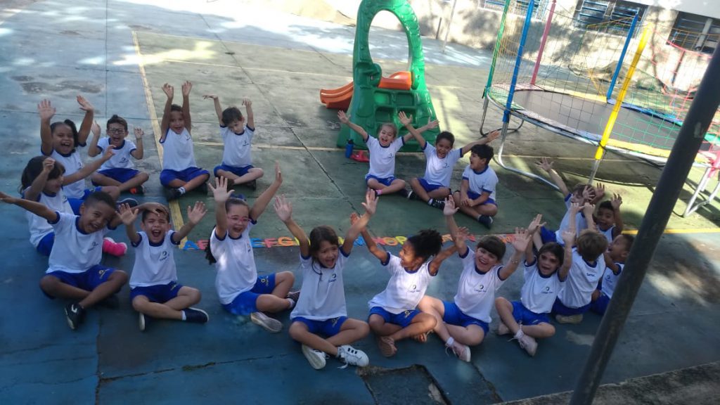 Crianças fazem atividade educativa em roda no pátio da escola